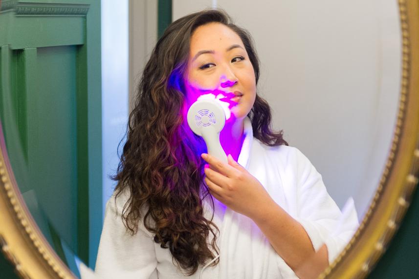 Woman using LED light to treat acne