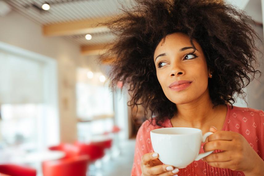 Woman smelling cup of coffee