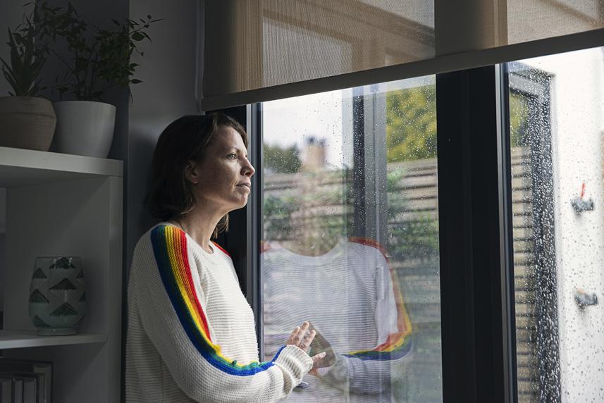 Woman looking sadly into her backyard  for an article on ambiguous grief