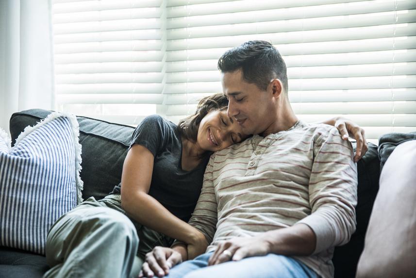 Couple on the couch hugging for an article about relationship anxiety