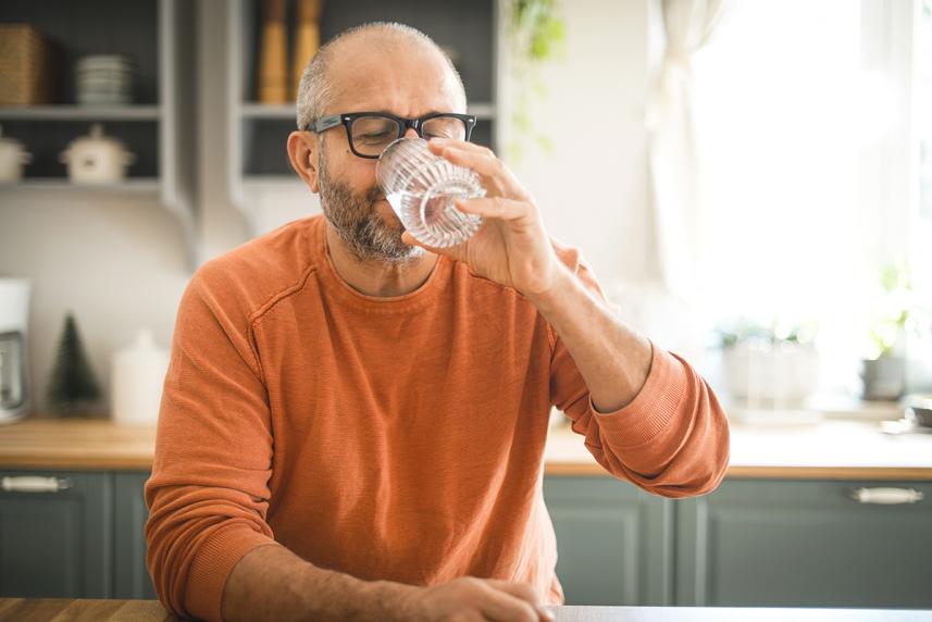Man drinking water to prevent headaches