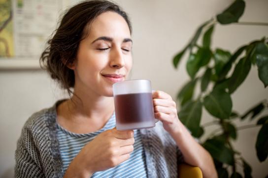 Woman smelling a cup of coffee