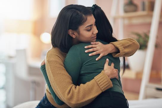 Woman grieving after miscarriage accepts a hug
